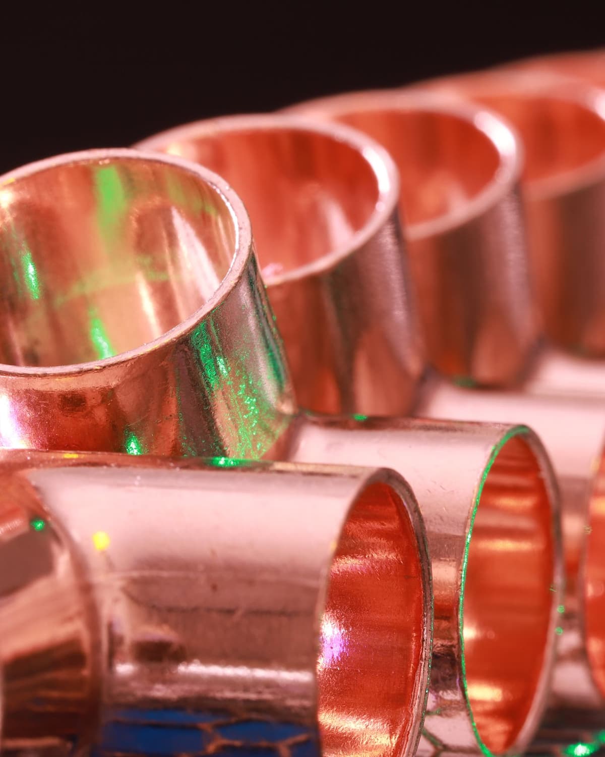 Close-up of rows of shiny copper pipe coupling fittings